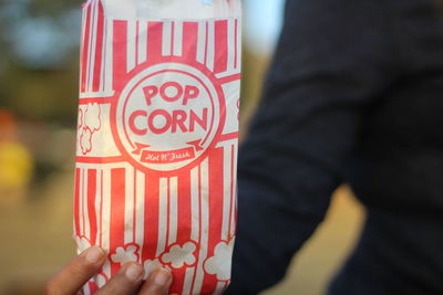 Midsection of man holding popcorn bag