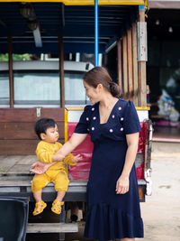 Side view of young woman standing in city