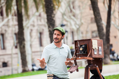 Portrait of young man photographing against trees