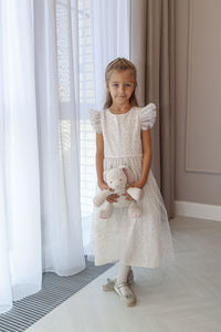 Full length portrait of girl standing at home