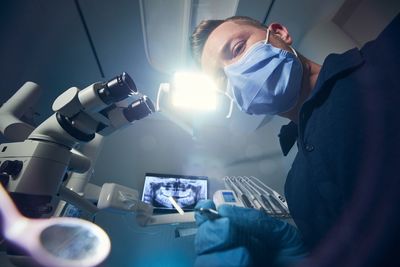 Low angle view of dentist wearing mask at clinic