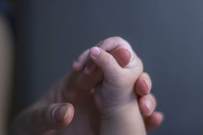 Baby holding hand of parent