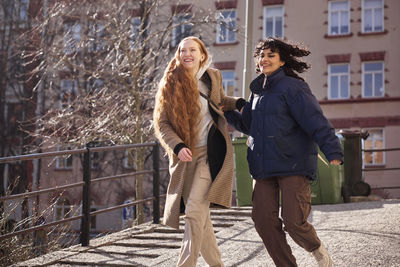 Female friends walking together ourdoors on walkway in city