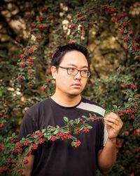 Portrait of young man standing against wall