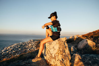 Full length of woman standing on rock at beach