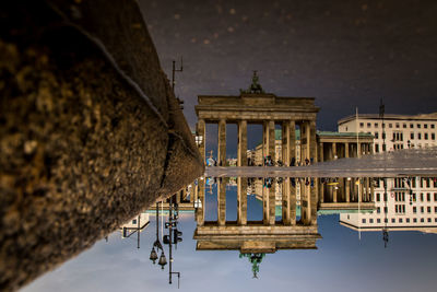 Reflection of brandenburg gate in puddle on street