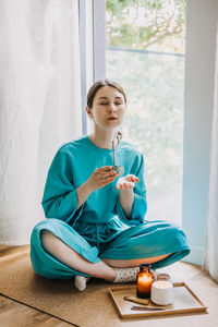 Young woman sitting on sofa at home