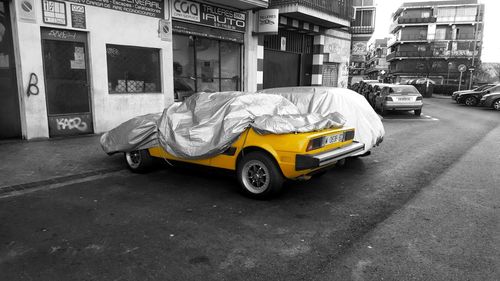 Car on street against buildings in city