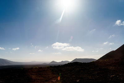 Scenic view of mountains against sky on sunny day
