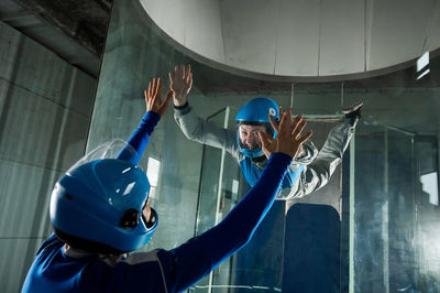 Low angle view of man with arms outstretched in building