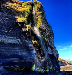 Low angle view of rock formations against clear blue sky