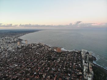 High angle view of buildings by sea against sky