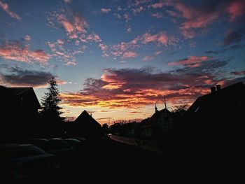 Buildings against cloudy sky at sunset