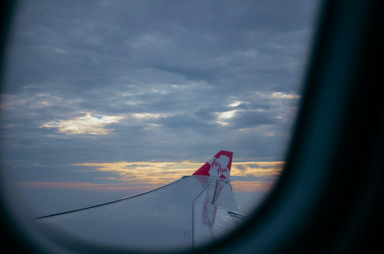 AIRPLANE WING AGAINST SKY DURING SUNSET