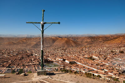 Wind turbines on landscape against clear blue sky