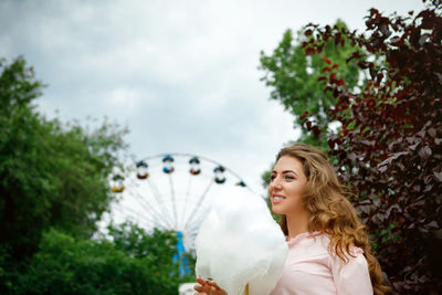 Smiling young woman holding cotton candy