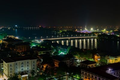 High angle view of illuminated buildings against sky at night