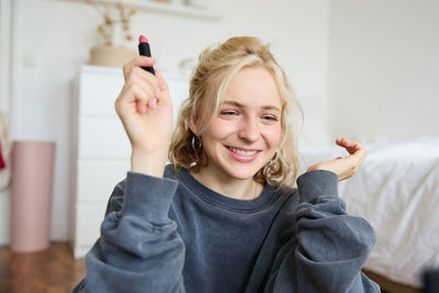 Portrait of smiling young woman using mobile phone