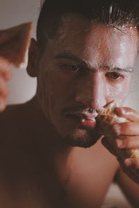 Close-up portrait of young man drinking glass