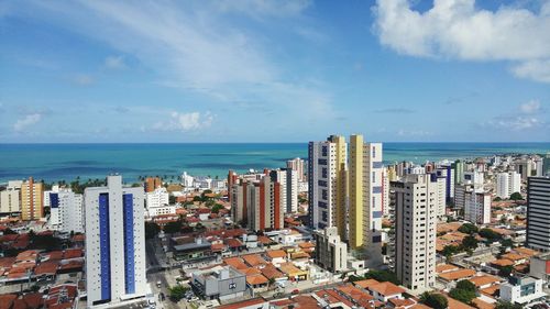 High angle view of cityscape by sea against sky