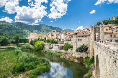 River amidst buildings in city against sky