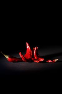 Close-up of red chili peppers against black background