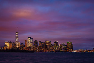 Illuminated buildings against sky during sunset