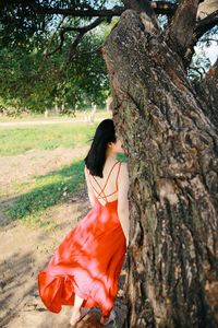 Woman looking at tree trunk