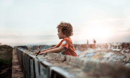 Side view of woman standing on railing