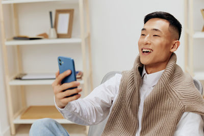 Portrait of young woman using mobile phone at home