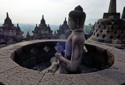 Statue of temple in building against sky