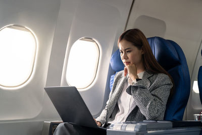 Businesswoman using laptop in airplane