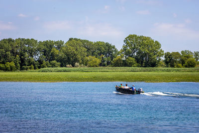 Boat sailing on river against sky