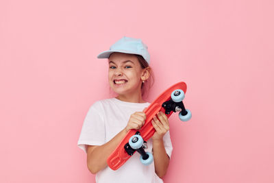 Portrait of boy with toy against pink background