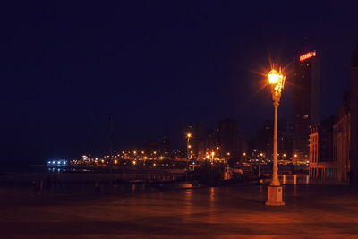 Illuminated city against clear sky at night