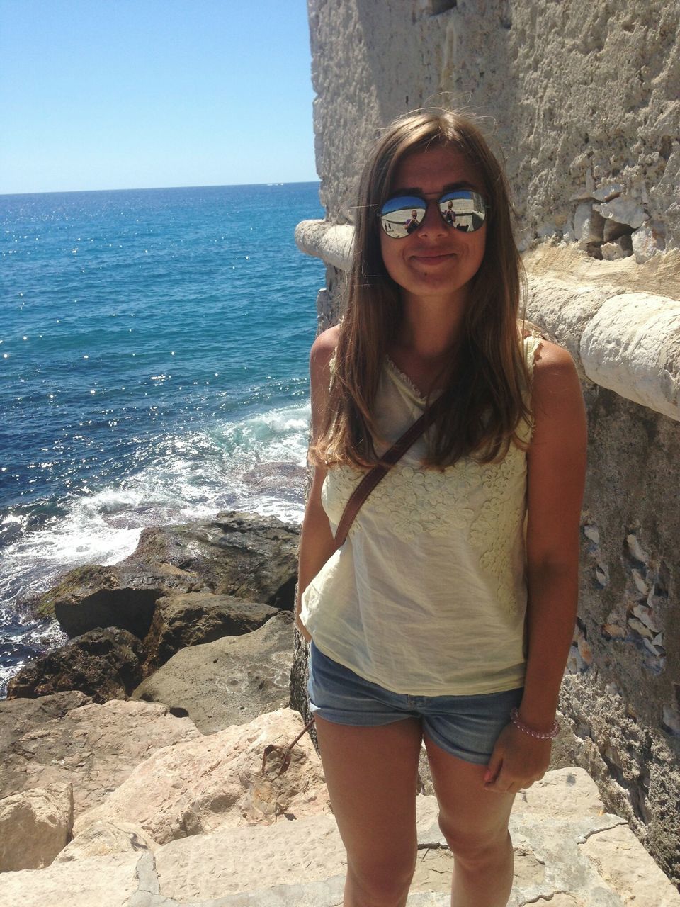 PORTRAIT OF YOUNG WOMAN STANDING ON BEACH