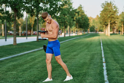 Full length of shirtless man in grass