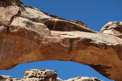 Low angle view of rock formation against clear blue sky