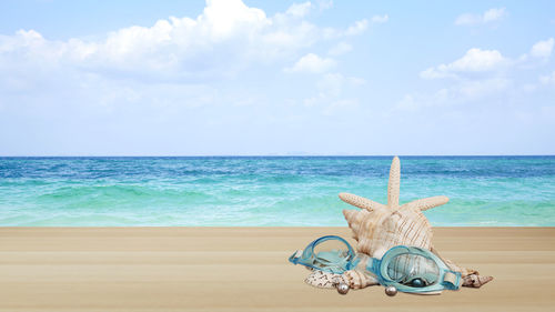 Deck chairs on beach against sky