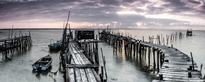 Pier over sea against sky during sunset