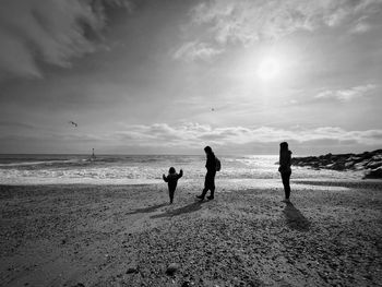 People on beach against sky