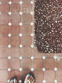 Low section of woman standing on cobblestone