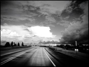Highway against cloudy sky