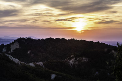 Scenic view of silhouette mountains against sky at sunset