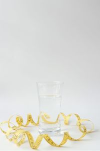 Close-up of empty glass on table against white background