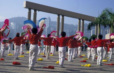 Rear view of children performing traditional dance on street