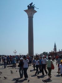 Tourists visiting monument against clear sky
