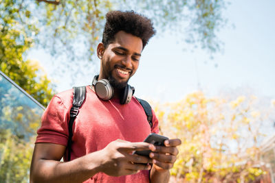 Low angle view of young man using mobile phone