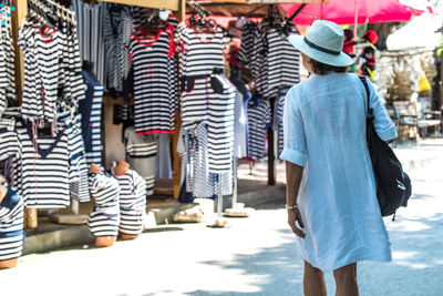 Rear view of woman shopping on street at market stall