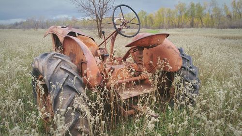 Rusty old abandoned tractor in field